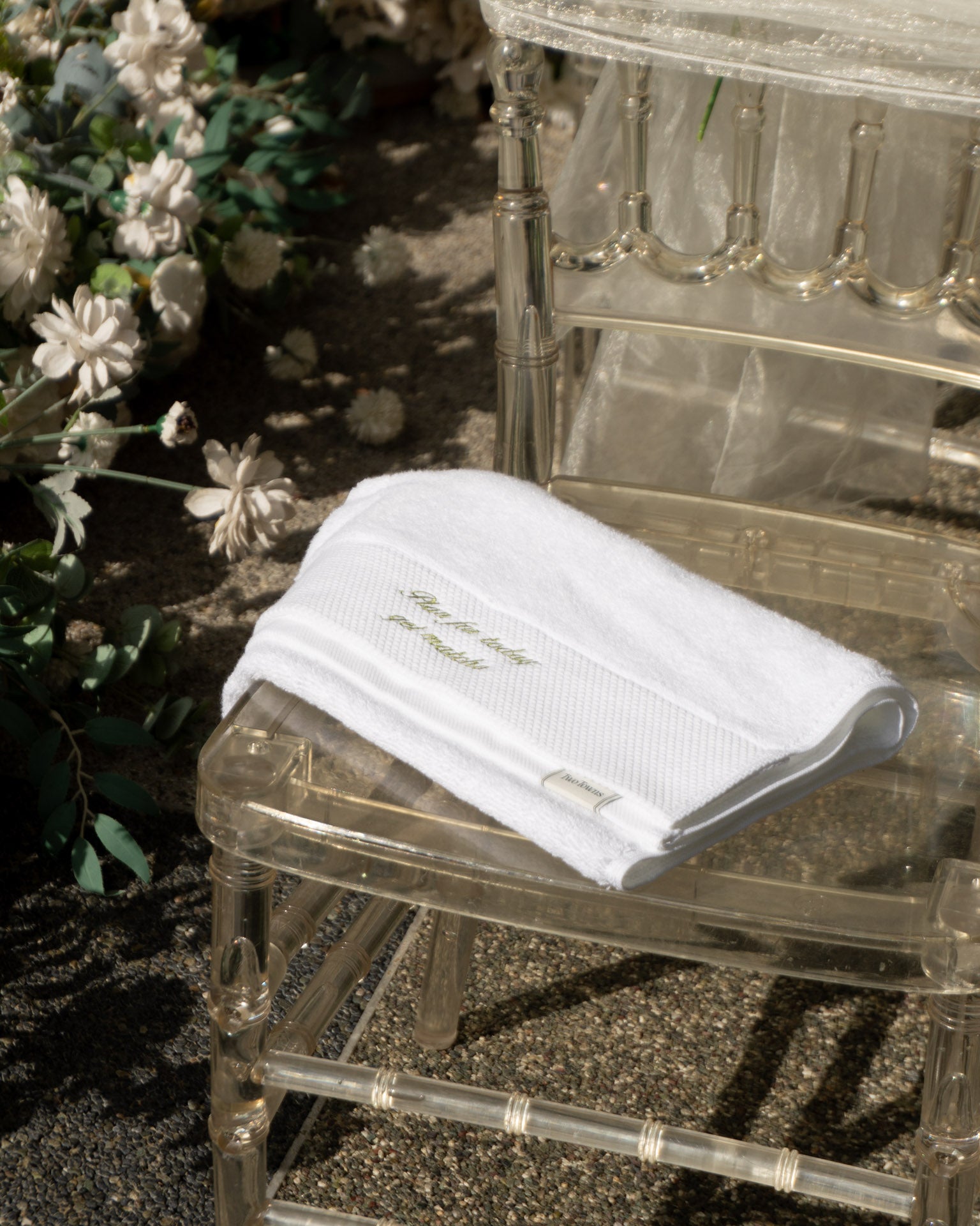 White towel with text on a clear chair outdoors
