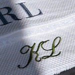 Close-up of embroidered initials on a white towel background